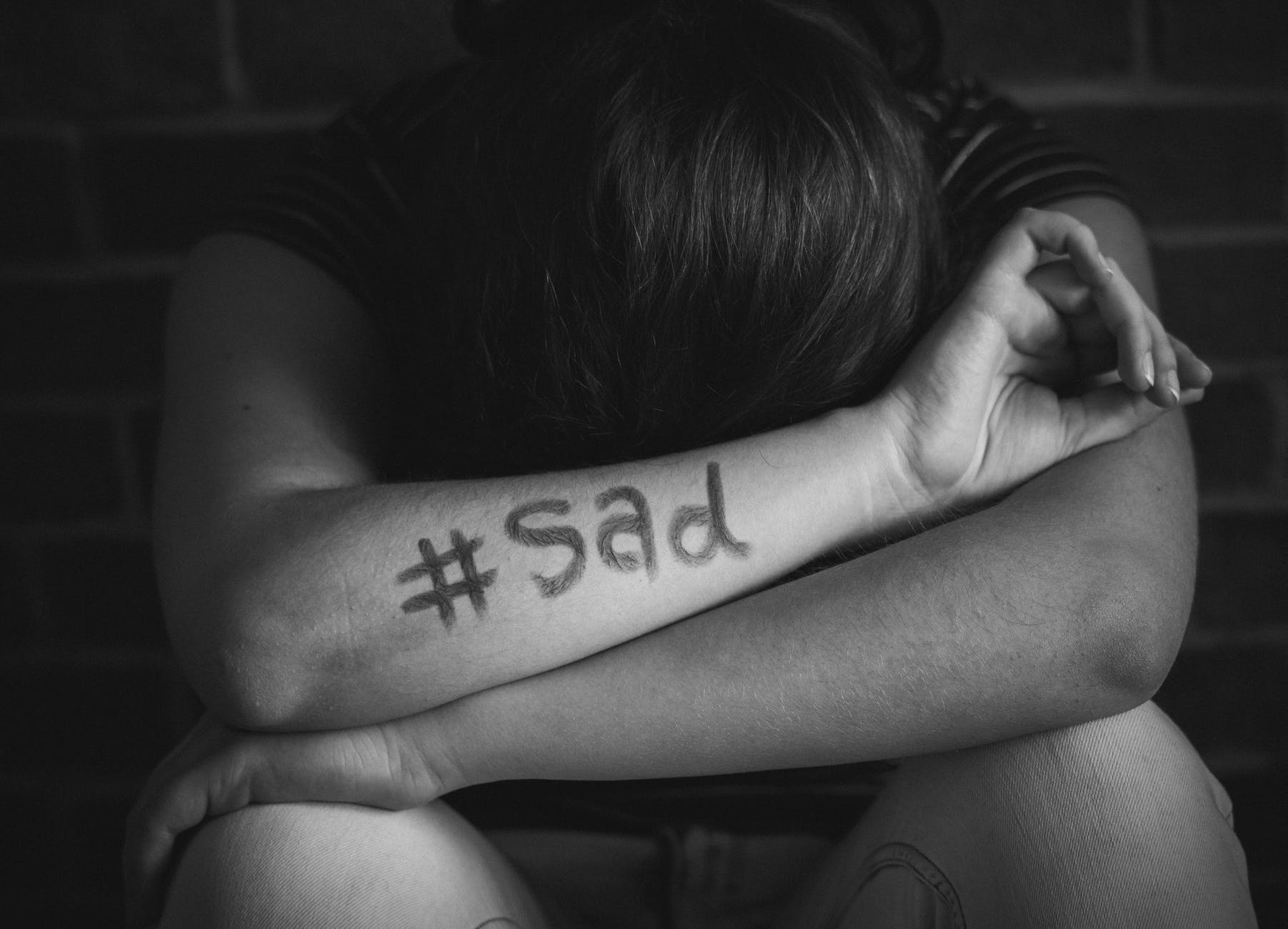 person leans on arms with sad text